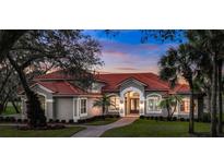 Stunning single-story home featuring a red tile roof, manicured landscaping, and a welcoming arched entryway at 3156 Winding Pine Trl, Longwood, FL 32779