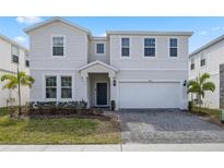 Charming two-story home featuring a paved driveway and an attached two-car garage at 4353 Lana Ave, Davenport, FL 33897
