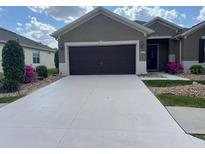Traditional home with a two-car garage, concrete driveway and manicured front lawn at 6832 Sw 93Rd Ave, Ocala, FL 34481