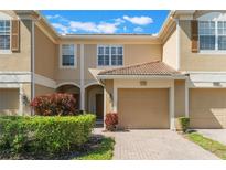 Inviting townhome featuring a one-car garage and a well-maintained lawn in a residential neighborhood at 6936 Hochad Dr, Orlando, FL 32819