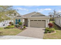 Charming home featuring a well-manicured lawn, paver driveway, and two-car garage at 7977 Hanson Bay Pl, Kissimmee, FL 34747