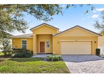 Charming single-story home featuring a brick driveway, manicured lawn, and neutral-toned facade at 9122 Stromboli Ct, Kissimmee, FL 34747
