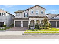 Charming two-story home with a two-car garage, lush landscaping, and a covered front porch at 9947 Summerlake Groves St, Winter Garden, FL 34787