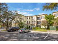 Multi-story condo building with reserved parking and lush landscaping, providing a welcoming curb appeal at 11564 Mizzon Dr # 305, Windermere, FL 34786