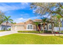 Charming single-story home boasts a well-manicured lawn, stone accents, and a two-car garage at 1411 Ellis Fallon Loop, Oviedo, FL 32765