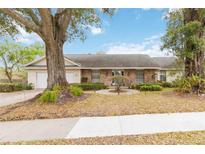 Charming home featuring a brick facade, large front yard, and a beautiful mature tree at 1432 Northridge Dr, Longwood, FL 32750