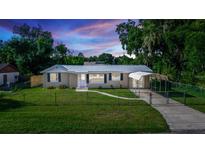 Charming home featuring a metal roof, covered parking, and well-maintained landscaping at 15 Palmira Rd, Debary, FL 32713