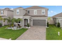 Two-story home featuring a two-car garage, tidy landscaping, and a welcoming front entrance at 2091 Brillante Dr, St Cloud, FL 34771