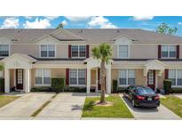 Charming townhome with red shutters, a palm tree, and a well-manicured front lawn at 2318 Silver Palm Dr, Kissimmee, FL 34747