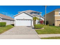 Charming two-story home featuring a two-car garage, well-maintained landscaping, and a brick paved driveway at 5239 Los Palma Vista Dr, Orlando, FL 32837