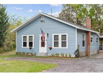 Charming blue home featuring white trim, an American flag, and well-maintained landscaping at 655 W Date St, Lake Wales, FL 33859