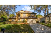 Charming two-story home with a well-manicured front yard and attached two car garage at 729 Strihal Loop, Oakland, FL 34787