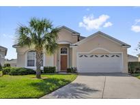 Charming single-Gathering home featuring a well-manicured lawn and a mature palm tree at 8136 Fan Palm Way, Kissimmee, FL 34747