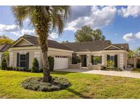 Charming single-story home featuring a well-manicured lawn and a beautiful palm tree in the front yard at 8929 Charleston Park # 12, Orlando, FL 32819