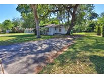 Charming single-story home with a spacious front yard and mature trees providing shade at 1055 W International Speedway Blvd, Daytona Beach, FL 32114