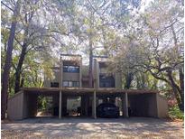 Exterior view of townhome with covered parking featuring mature trees at 116 Crown Oaks Way # 116, Longwood, FL 32779