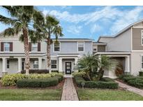 Charming two-story home with landscaped yard, lush palms, and welcoming front entryway at 12024 Sonnet Ave, Orlando, FL 32832