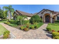 Charming single-story home featuring lush landscaping and a brick walkway leading to the front door at 12860 Jacob Grace Ct, Windermere, FL 34786