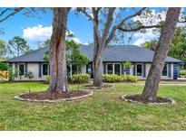 Charming home with mature trees, manicured lawn, and neutral exterior paint with blue trim at 137 Spring Chase Cir, Altamonte Springs, FL 32714