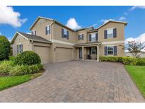 Inviting two-story home with a well-manicured lawn and three-car garage at 1722 Lake Sims Pkwy, Ocoee, FL 34761