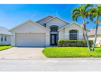 Charming single-Gathering home with lush lawn, manicured bushes, and a two-car garage at 215 Elderberry Dr, Davenport, FL 33897