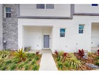 Contemporary townhome exterior with gray accents, manicured landscaping, and a welcoming entrance at 257 Famagusta Dr, Davenport, FL 33896