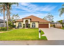 Charming single-story home with well-manicured lawn, lush landscaping, and a two-car garage at 2726 Babbitt Ave, Orlando, FL 32833