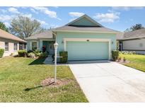 Charming single-Gathering home with a two-car garage, lush landscaping, and a well-manicured lawn at 3726 Mount Hope Loop, Leesburg, FL 34748