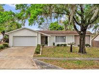 Charming single-story home with a well-maintained lawn, mature tree, and a two-car garage at 414 Sundown Trl, Casselberry, FL 32707