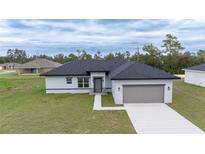 New construction home featuring a two-car garage, neutral paint, and a well-manicured lawn at 4415 Sw 169Th Lane Rd, Ocala, FL 34473