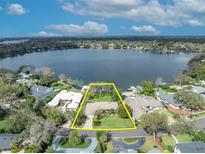 Breathtaking aerial view of a lakefront property with lush landscaping and direct access to the water at 443 Lakewood Dr, Winter Park, FL 32789