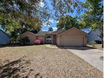 Charming single-story home with mature trees, a two-car garage, and a well-maintained front yard at 8040 Equitation Ct, Orlando, FL 32818