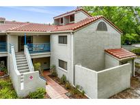 Charming two-story condo features a red tile roof, stucco exterior, and a welcoming blue railing at 1000 Winderley Pl # 237, Maitland, FL 32751