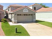 Two-story home featuring an attached two car garage, concrete driveway, and well manicured lawn at 1009 Troon Trce, Winter Springs, FL 32708