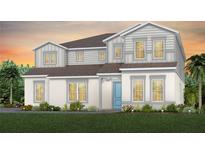 Charming two-story home showcasing light gray accents, well-manicured lawn, and an inviting blue front door at 15196 Willow Ridge Dr, Montverde, FL 34756