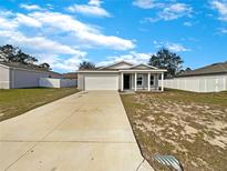 Charming single-story home features a two-car garage and a classic facade, set on a spacious lot under a bright, cloudy sky at 209 Fig Ct, Kissimmee, FL 34759