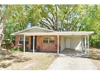 Charming brick home with a carport, beautiful landscaping, and a welcoming entrance at 2519 Poinsetta Ave, Sanford, FL 32773