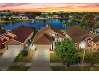 Beautiful waterfront property with mature landscaping and stunning sunset views over the lake at 4916 Cedarstone Lane, Orlando, FL 32822