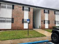 Brick two-story condominium with a handicap parking sign in front at 5317 Curry Ford Rd # Q104, Orlando, FL 32812