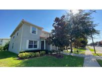 Two-story home featuring a well-maintained lawn and landscaping with inviting shuttered windows and a red tile roof at 8991 Cuban Palm Rd, Kissimmee, FL 34747