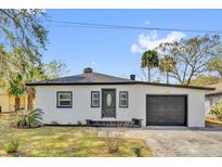 Charming single-story home with stucco exterior, dark trim, and a well-manicured front yard at 1240 Moton Ave, Sanford, FL 32771