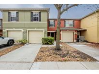 A view of the townhome's exterior showcasing a two-story design, driveway, and attached garage at 13441 Starry Night Ct # 9, Orlando, FL 32824