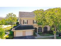 Charming home featuring a tile roof, two-car garage, and nicely landscaped grounds with lush green trees at 14205 Falls Church Dr # 2001, Orlando, FL 32837