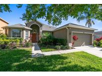 Charming single-story home featuring a well-manicured lawn and beautiful landscaping at 150 Magnolia Park Trl, Sanford, FL 32773