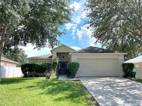 Charming single-story home featuring a well-manicured lawn and a two-car garage at 2413 Sandridge Cir, Eustis, FL 32726