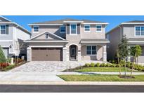 Charming two-story home with a paver driveway, a two car garage and nicely manicured lawn at 273 Auburn Ave, Kissimmee, FL 34747