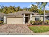 Charming single-story home with brick driveway, lush landscaping, and inviting entryway at 346 Vista Oaks Way, Davenport, FL 33837