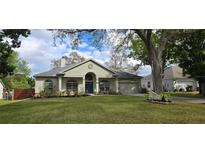 Charming single-story home with a well-manicured lawn and lush landscaping at 3887 Kingston Oaks Cv, Oviedo, FL 32765