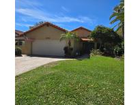 Charming single-story home featuring a tile roof, lush landscaping, and a well-manicured lawn at 6552 Edgeworth Dr, Orlando, FL 32819