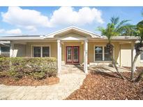 Charming front entrance with red double doors, covered porch, and landscaped walkway, offering curb appeal at 6762 Tamarind Cir, Orlando, FL 32819